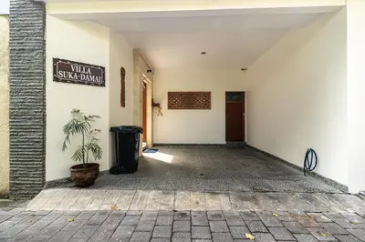 a hallway with a trash can and a sign on a wall at Villa Suka Damai Peaceful 2 Bedroom Getaway in Seminyak
