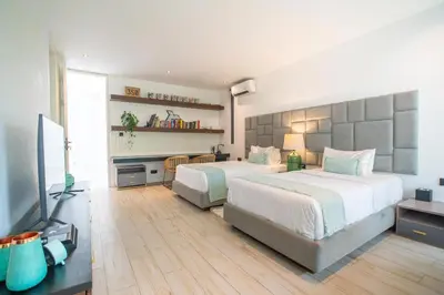 a bedroom with two beds and a flat screen tv at House of Light 5bed villa in Canggu