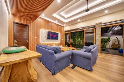 a living room with two blue chairs and a table at Seminyak Happy Villa in Legian