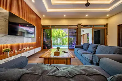 a living room with blue couches and a coffee table at Seminyak Happy Villa in Legian