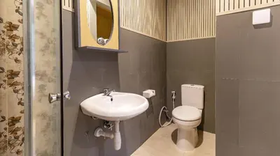 a bathroom with a sink and a toilet and a mirror at AA Inn Kuta Beach in Ngurah Rai International Airport