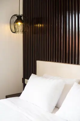 a bedroom with a white bed and a black wall at Harmoni Lane Studios in Seminyak