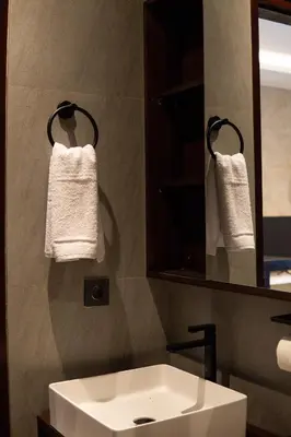 a bathroom with a sink and a mirror and towels at Harmoni Lane Studios in Seminyak