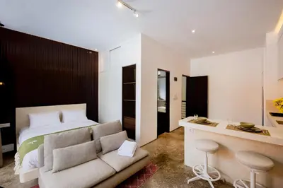 a bedroom with a bed and a couch and a desk at Harmoni Lane Studios in Seminyak