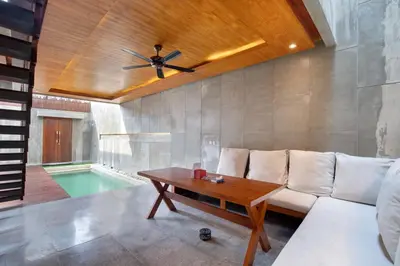 a living room with a couch and a ceiling fan at Aqilah Villa Bali in Legian