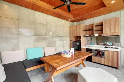 a living room with a wooden table and chairs at Aqilah Villa Bali in Legian