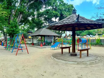 a playground with an umbrella and slides and swings at Apartment at Jayakarta Residence Beach Front Access in Seminyak