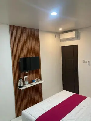 a hotel room with a bed and a television at Hotel Sanrina Kuta Bali in Kuta