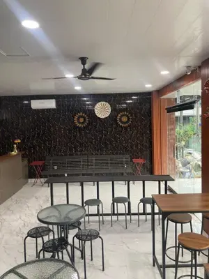 a restaurant with tables and chairs and a bench at Hotel Sanrina Kuta Bali in Kuta