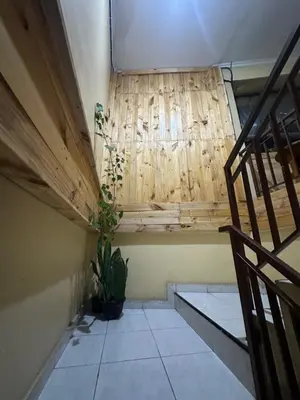 a room with a staircase and a wooden wall at Sari Buana Bed & Breakfast in Kuta