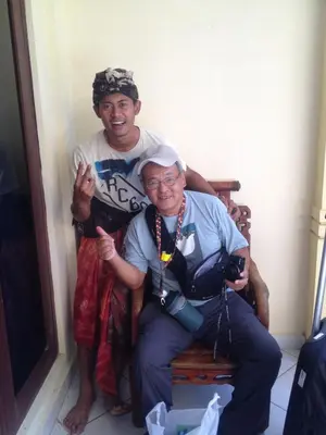 a man and an older woman sitting on a bench at Sari Buana Bed & Breakfast in Kuta