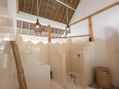 a room with a toilet in a room with lights at Villa Santai by Optimum Bali Villas in Canggu