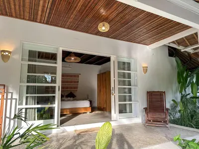 a room with a bedroom with a bed and a window at Villa Santai by Optimum Bali Villas in Canggu