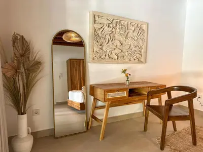 a desk and chair in a room with a mirror at Villa Santai by Optimum Bali Villas in Canggu