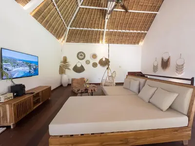 a living room with a couch and a tv at Villa Santai by Optimum Bali Villas in Canggu