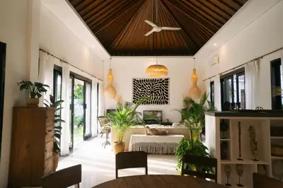 a living room with a wooden ceiling and plants at Splendid 3 BR villa with large pool and garden in Canggu