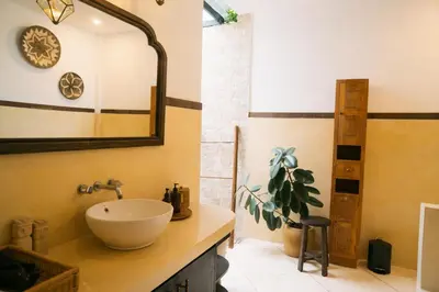 a bathroom with a sink and a mirror at Splendid 3 BR villa with large pool and garden in Canggu