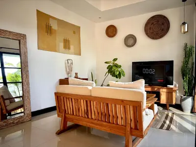 a living room with a couch and a tv at Villa Omarama Seminyak Beach in Seminyak