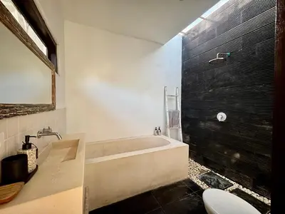 a bathroom with a bath tub and a toilet at Villa Omarama Seminyak Beach in Seminyak