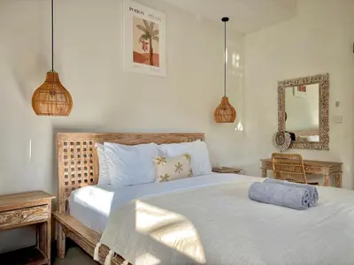 a bedroom with a large bed and a mirror at Villa Omarama Seminyak Beach in Seminyak