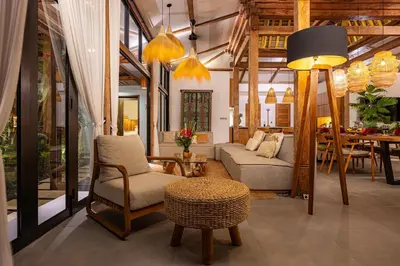 a living room with a couch and a chair and a table at Villa Sebelah by Optimum Bali Villas in Seminyak