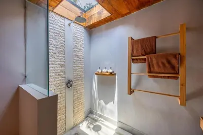a bathroom with a shower with a glass door at Villa Sebelah by Optimum Bali Villas in Seminyak