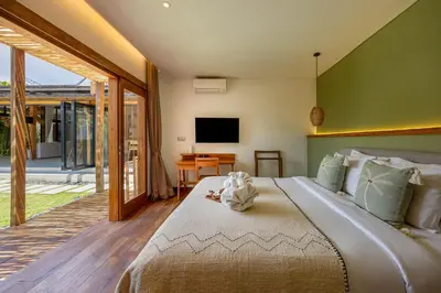 a bedroom with a large bed and a television at Villa Sebelah by Optimum Bali Villas in Seminyak