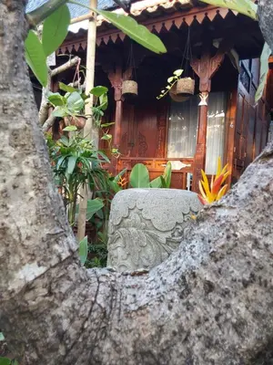 a stone bench in front of a house at Navalia Rumah Kayu in Kerobokan