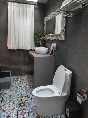 a bathroom with a toilet and a sink at Navalia Rumah Kayu in Kerobokan