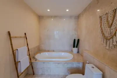 a bathroom with a tub and a toilet at Boholuma Villas by Pertama Management in Seminyak
