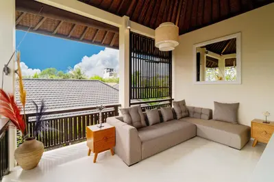 a living room with a couch and a large window at Boholuma Villas by Pertama Management in Seminyak