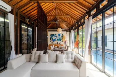 a living room with a white couch and large windows at Boholuma Villas by Pertama Management in Seminyak