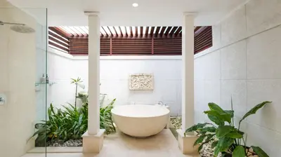 a bathroom with a bath tub and some plants at Villa Alun by Villa Finder in Canggu