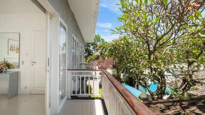 a balcony with a view of the trees at Villa Alun by Villa Finder in Canggu