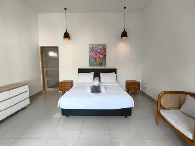a bedroom with a bed and two tables and a couch at Villa Videl in Seminyak