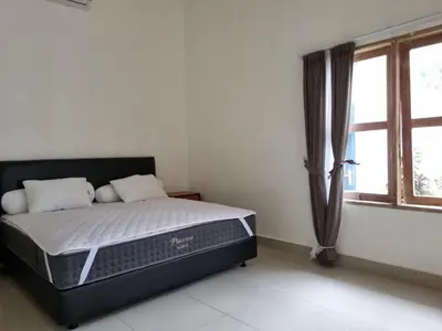 a bed sitting in a room with a window at Villa Videl in Seminyak