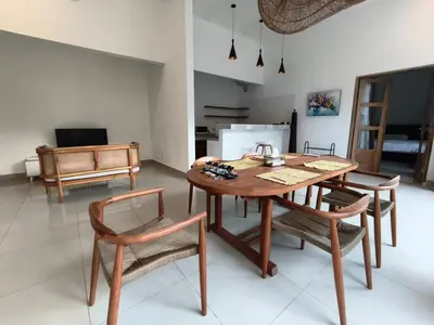 a dining room with a wooden table and chairs at Villa Videl in Seminyak