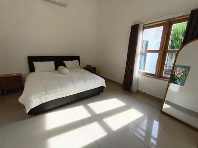 a bedroom with a bed and a large window at Villa Videl in Seminyak