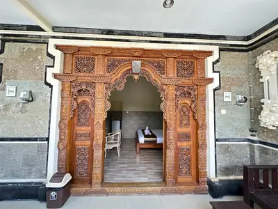 an entrance to a building with an ornate wooden door at Osa Guest House 5 in Seminyak