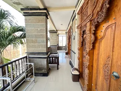 a corridor of a building with a balcony at Osa Guest House 5 in Seminyak