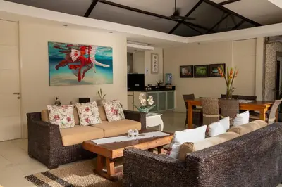 a living room with two couches and a table at Villa Kazari Zen in Seminyak