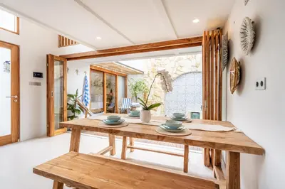 a wooden table and bench in a room with a window at Villa Monstera A7 By Aishwarya International in Kerobokan