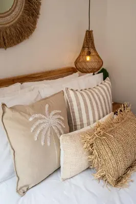 a bed with two pillows and a palm tree pillow at Villa Monstera A7 By Aishwarya International in Kerobokan