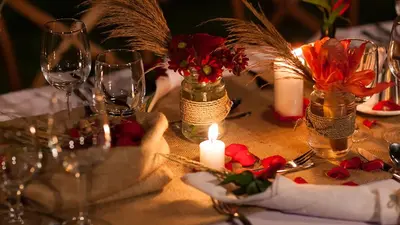 a table with wine glasses and flowers and candles at Villa The Beji in Canggu