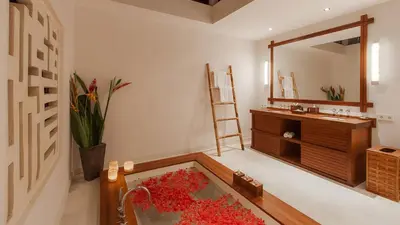 a bathroom with a sink and a tub filled with red flowers at Villa The Beji in Canggu