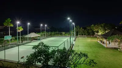 a tennis court at night with lights at Villa The Beji in Canggu