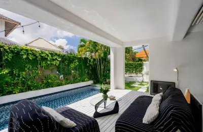 a living room with a swimming pool next to a house at Villa with 2 Bedrooms & Private Bathrooms near to the beach Seminyak in Seminyak