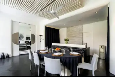 a dining room with a black table and white chairs at Villa with 2 Bedrooms & Private Bathrooms near to the beach Seminyak in Seminyak