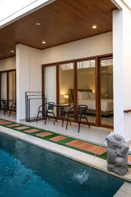 a house with a swimming pool with a fountain at The Saren CoLiving by SooBali in Kerobokan