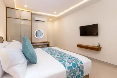 a bedroom with a bed and a tv on the wall at The Saren CoLiving by SooBali in Kerobokan